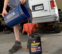 Photo of a someone dumping oil in the wrong containers may be a source of toxic waste in rivers and streams.