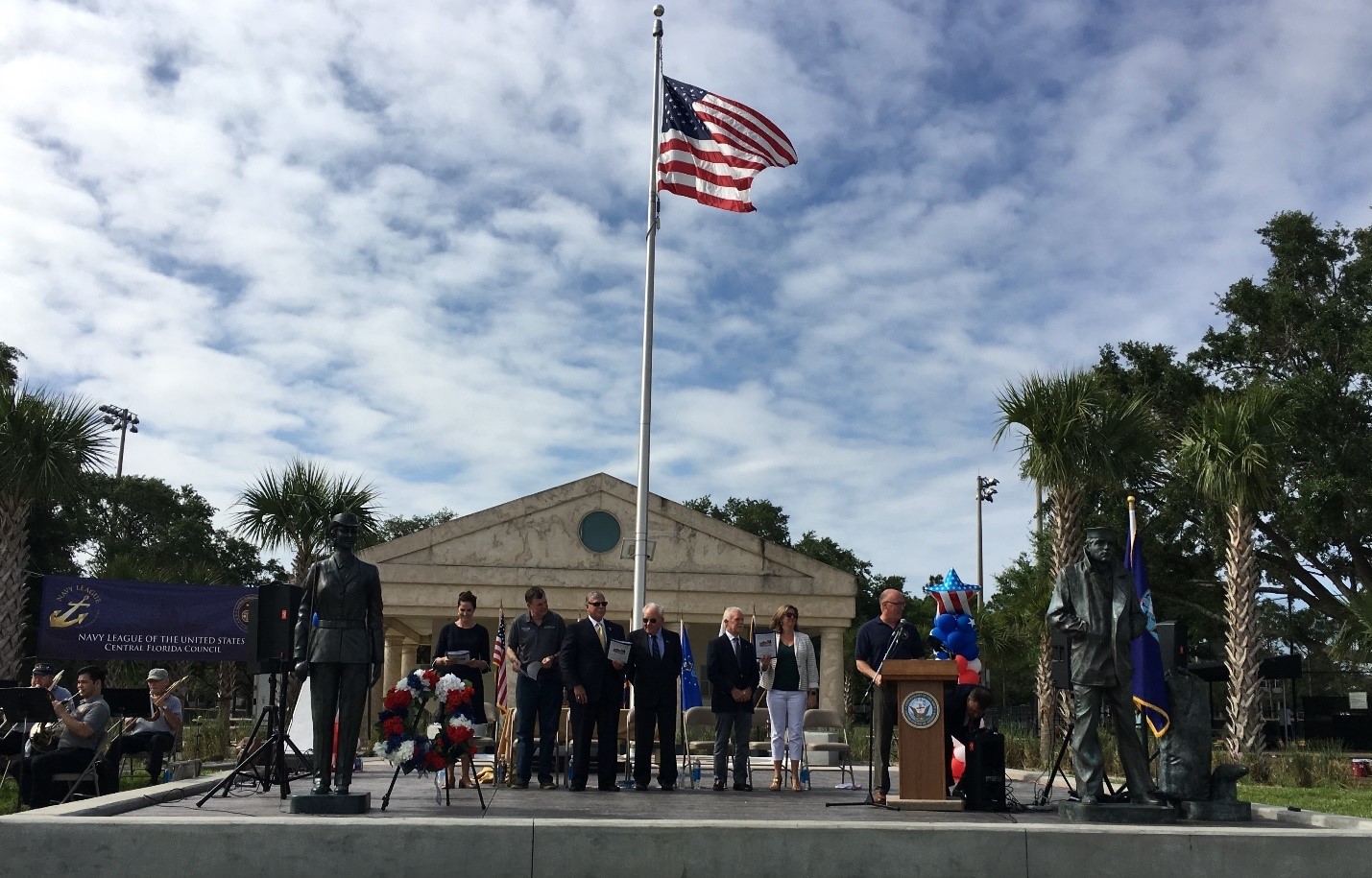 Group of people giving speech in front of Blue Jacket Park