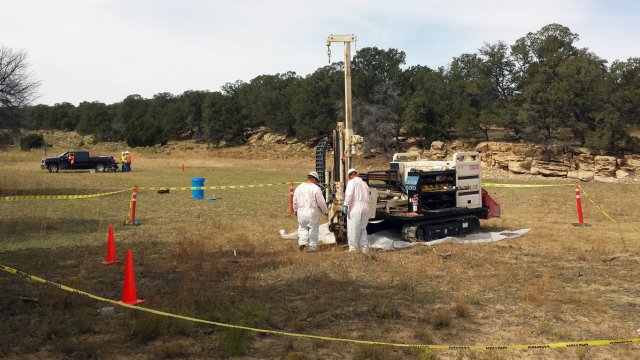 Crew with a mobile drill working in the middle of an open field