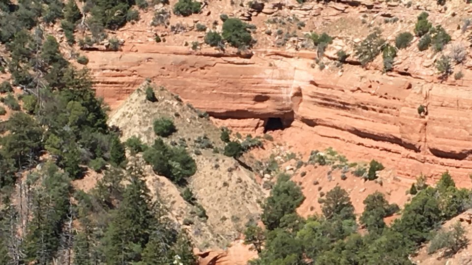 Steep cliffside with an open mine entrance