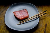 Fish on plate with chopsticks.