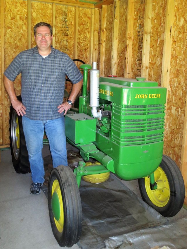 Robert Weber standing in front of an antique tractor on his family farm