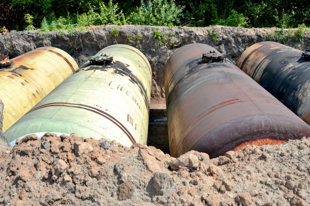 Photograph of underground storage tanks; soil has been removed from the top of the tanks to reveal where they are located underground.