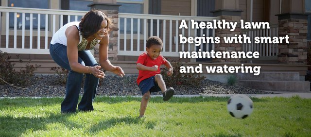 Mother playing soccer with son on a healthy lawn.