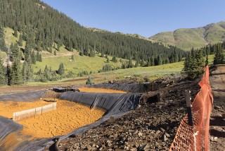 Orange tinged water running through a valley