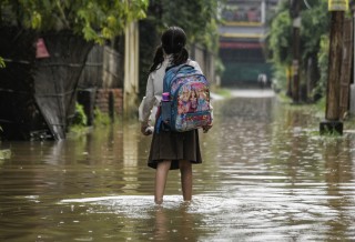 girl with backpack in flood water