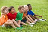 children sitting on a field of grass