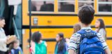 Kids getting on a school bus.