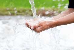 A stream of water falling into cupped hands