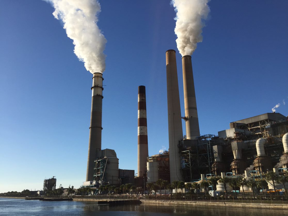 a power plant with three cooling towers emitting plumes