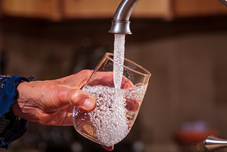 Cup being filled with water from a faucet