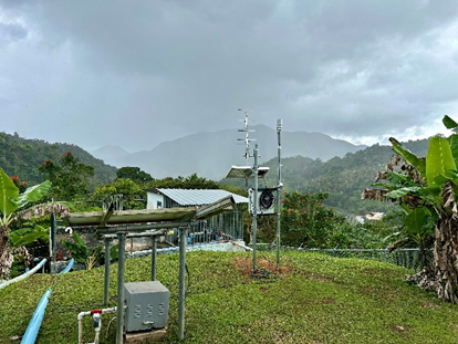 Small water system on a hill with pipes and surrounding vegetation