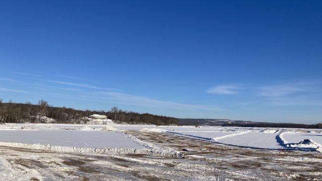 Contractor constructing ice roads in the Shallow Sheltered Bay to prepare for mechanical dredging.
