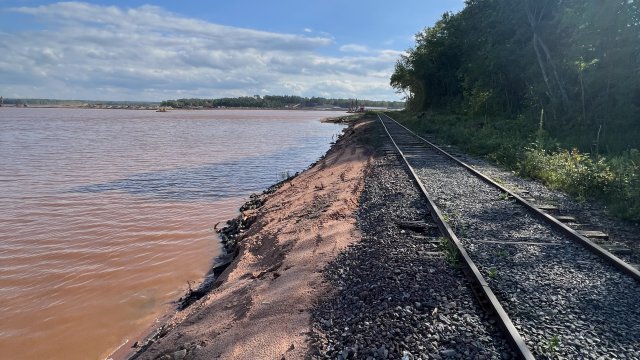 Fresh sand along the Shallow Sheltered Bay shoreline and a view of the railroad tracks along the shore. 