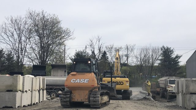 Contaminated heavy equipment is power washed