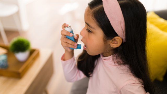 A girl using an inhaler.
