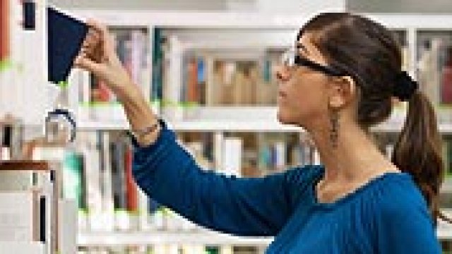 Woman browsing reports in a library