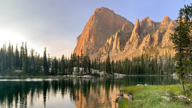 Rocky mountain peaks behind a serene alpine lake.