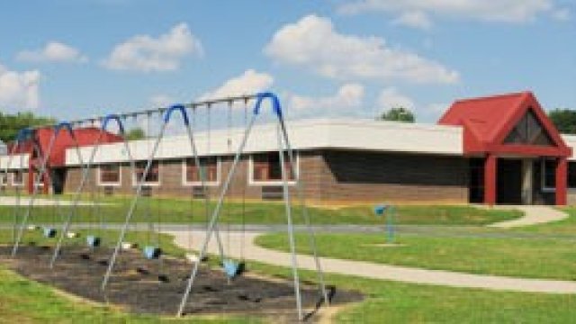school building with playset in foreground