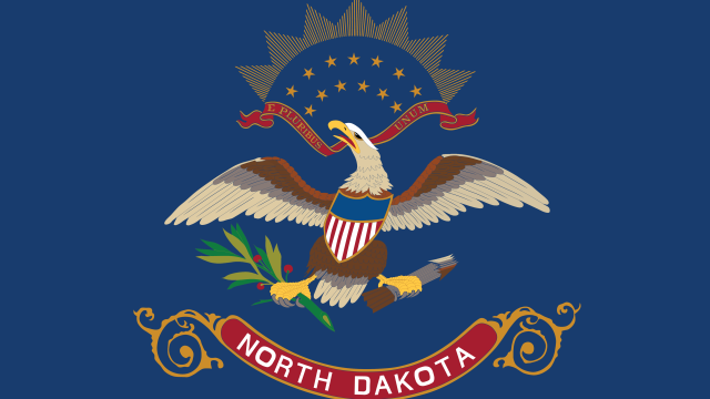 State flag of North Dakota showing the state seal and the motto,"E Pluribus Unum." Adobe Stock image.