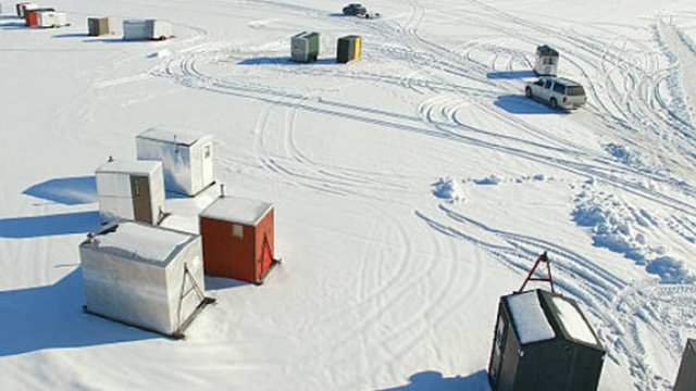 Aerial view of small sheds on a snowy frozen landscape