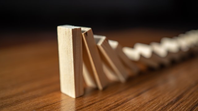 Falling dominoes on wooden table