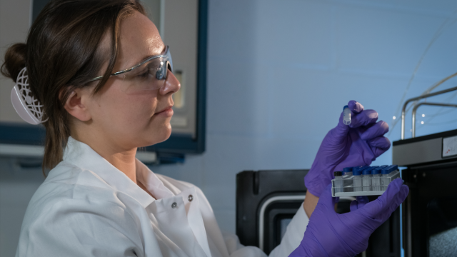 EPA researcher Anna Robuck wears personal protective equipment while examining samples.