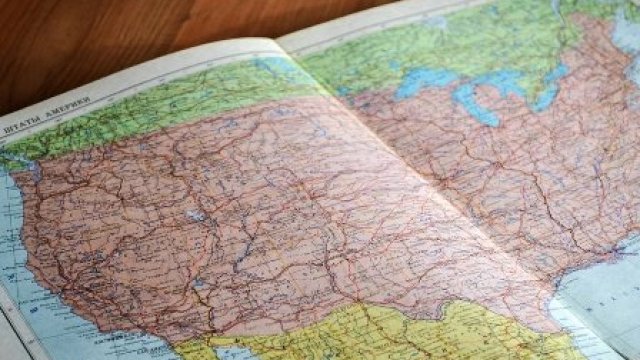 Open book laying on a desk displaying a map of the US