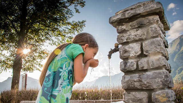 Girl drinking from outdoor water fountain