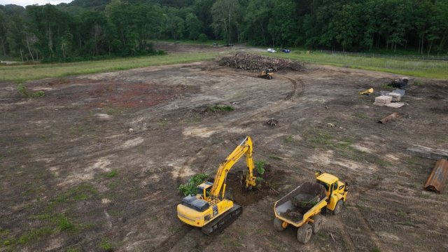An aerial image of the Sediment Placement Area with an excavator and mock dump truck hauling woody debris.