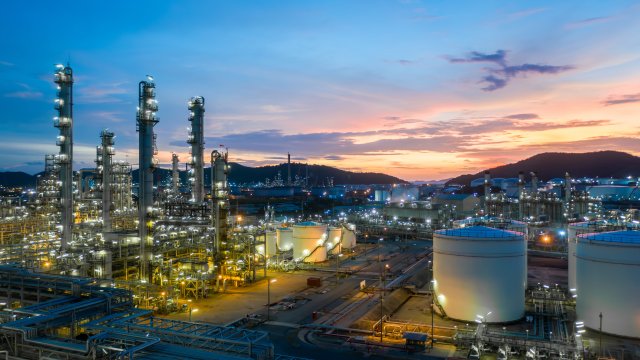 Industrial complex with lights on as sun sets