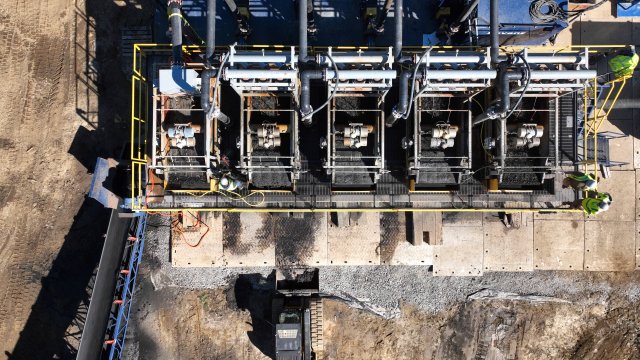 Aerial image with construction equipment on bare ground.
