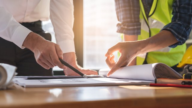 two people pointing at papers