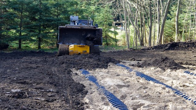 Excavator filling in soil