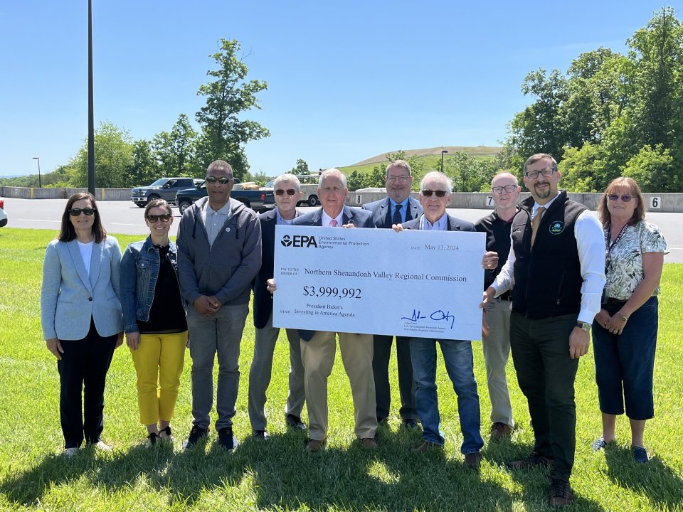 Partners holding a ceremonial check.