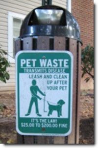 Sign text: Pet Waste Transmits Disease. Leash and clean up after your pet. It's the law! $25.00 to $200.00 Fine.