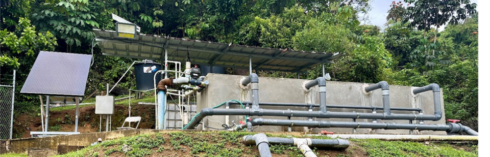 Small hillside water system with pipes in remote forested terrain