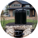 black cistern for collecting rainwater sits in front of a residence