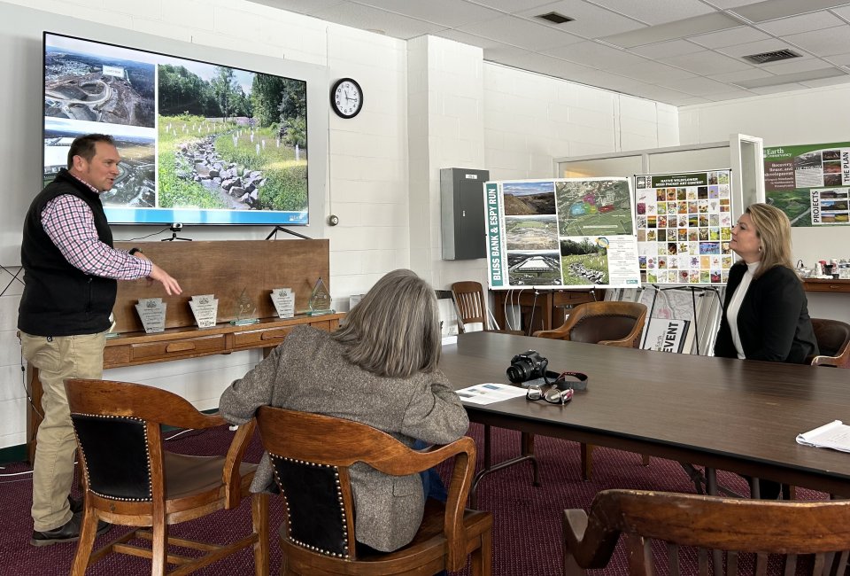 Man presents slides to two spectators