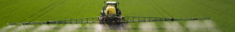 farm tractor spraying pesticides on a green field.
