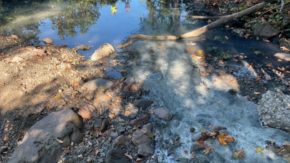 White, odorous residue flowing through an Elizabeth River tributary in Hillside, NJ.