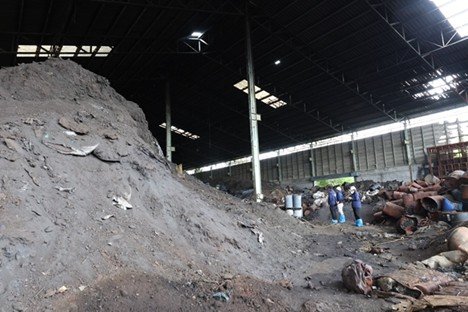 2-story solid waste and waste containers being inspected by workshop participants in an abandoned building.