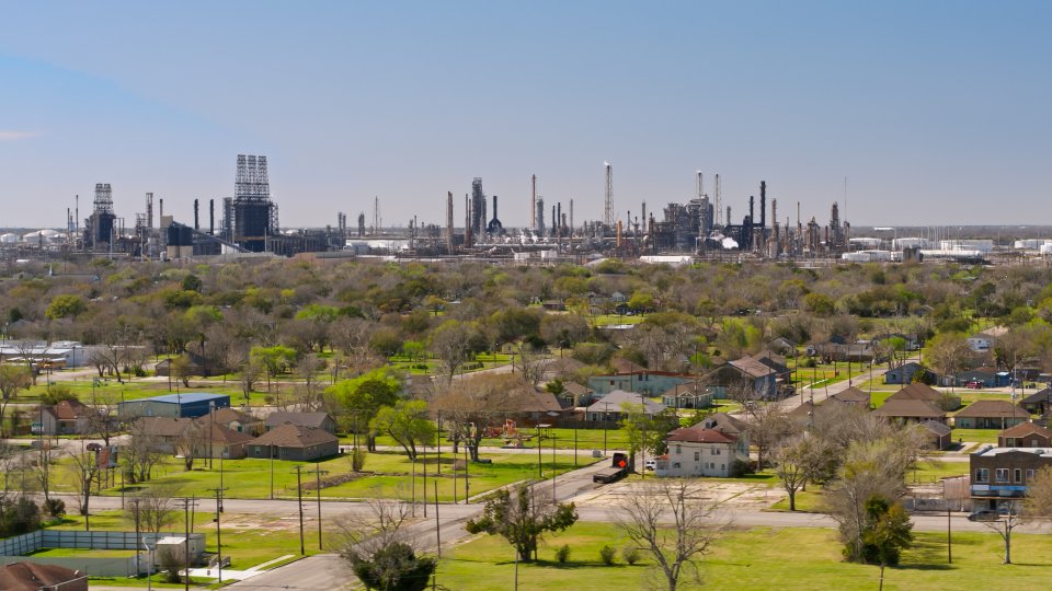 Panoramic view of a residential area with a large industrial complex in the background.
