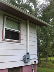 the outside of a house showing a radon mitigation system