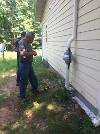 a radon technician outside of a home.