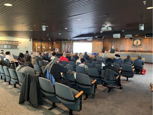 People sitting in Portsmouth City Hall listening to an EPA Region 3 representatives speak.