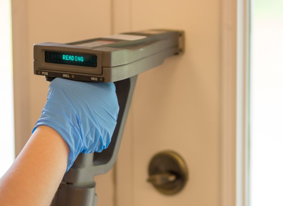 A person using an XRF to test for lead paint