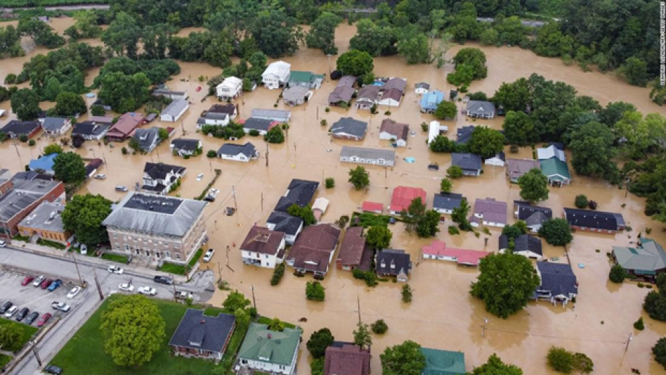 High flood waters surround houses and other buildings in a small town.