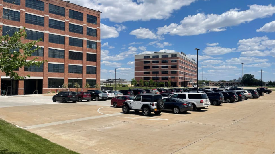 Parking lot with cars in front of two office buildings.