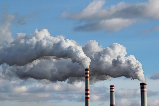 smoke comes out of a smoke stack into the air